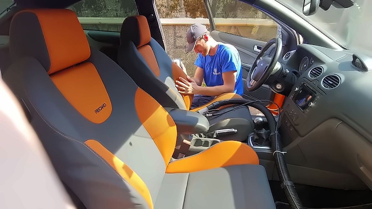 Radnik Clean Teama dubinski čisti sjedišta u vozilu